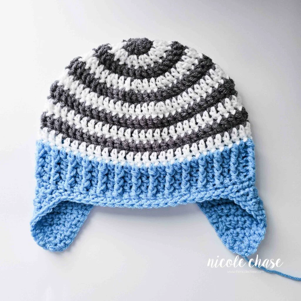 The single crochet edging around the brim and earflaps of the Spirit Earflap Hat crochet pattern has been completed, prior to weaving in ends. 