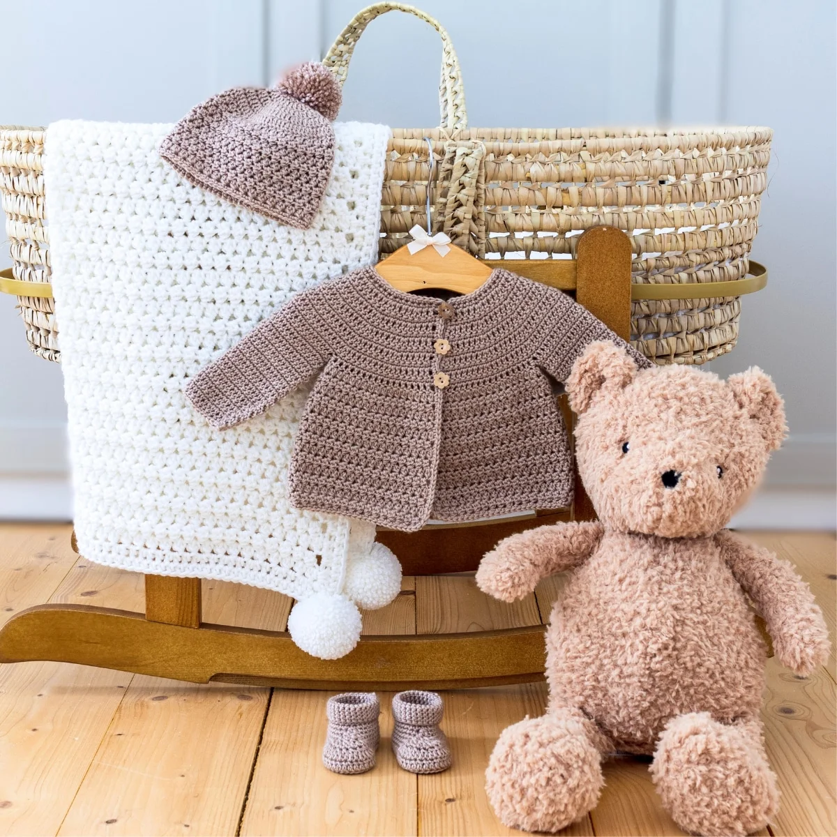 Crochet baby cardigan pattern styled with baby clothes handmade baby shower gift