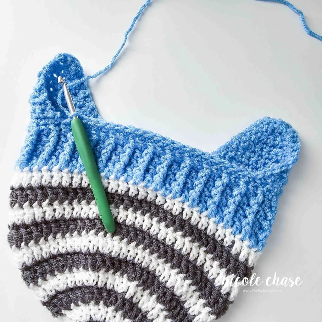 Continue crocheting around the brim of this crochet earflap hat. 