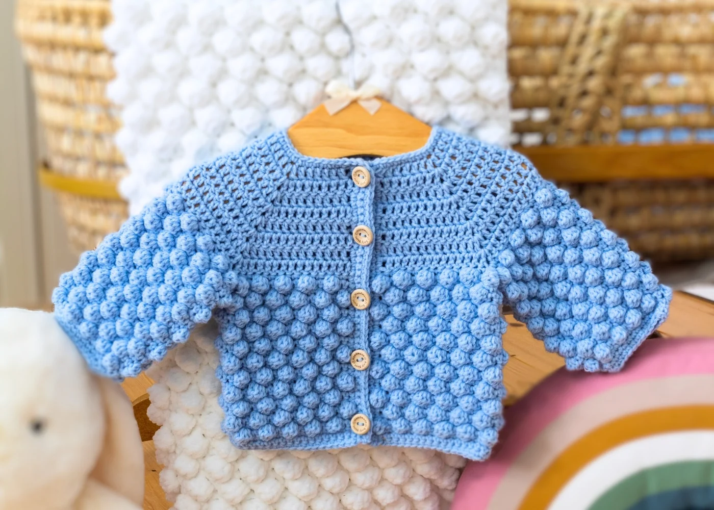 Bobble Crochet Baby Cardigan Pattern free hanging over cot